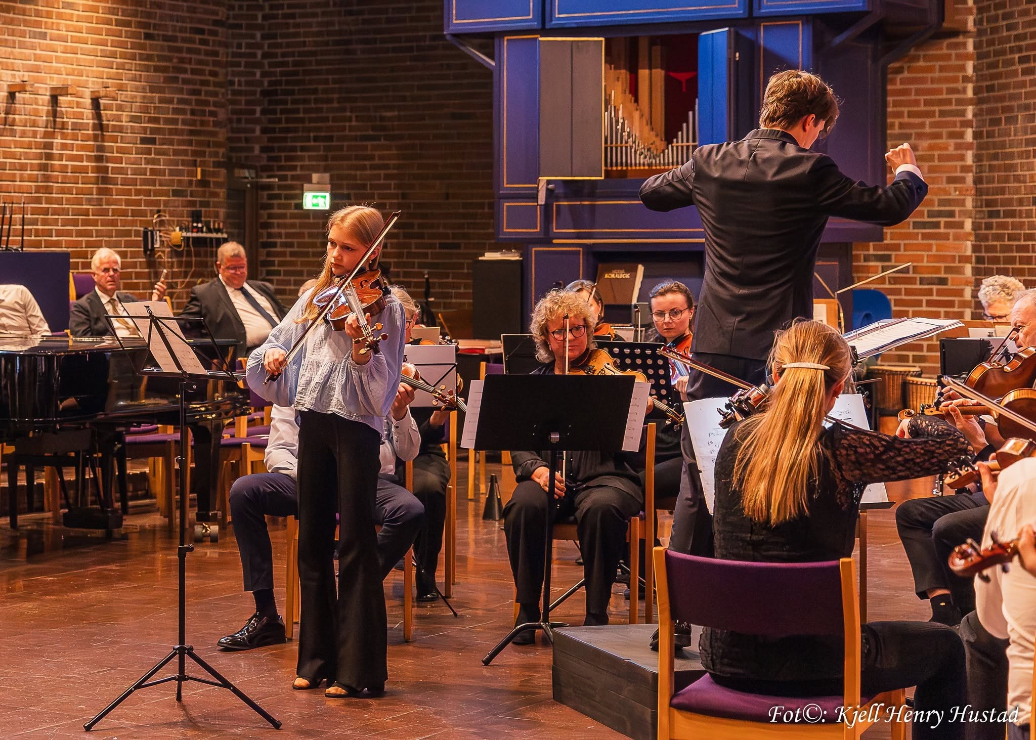 Fiolinsolist spiller med orkesteret